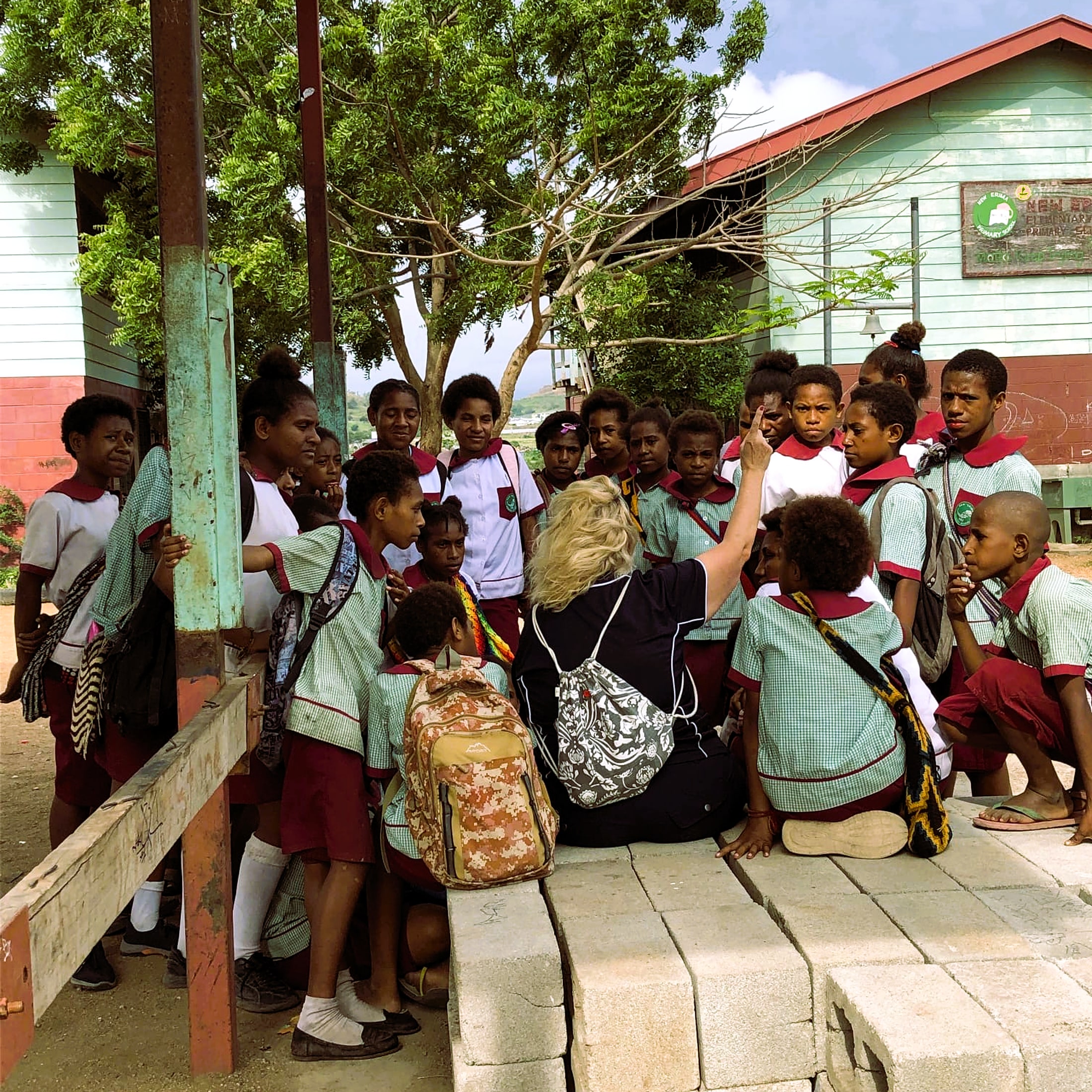 Linda Conkey sitting with a group of local students on a mission trip, engaging with them directly.